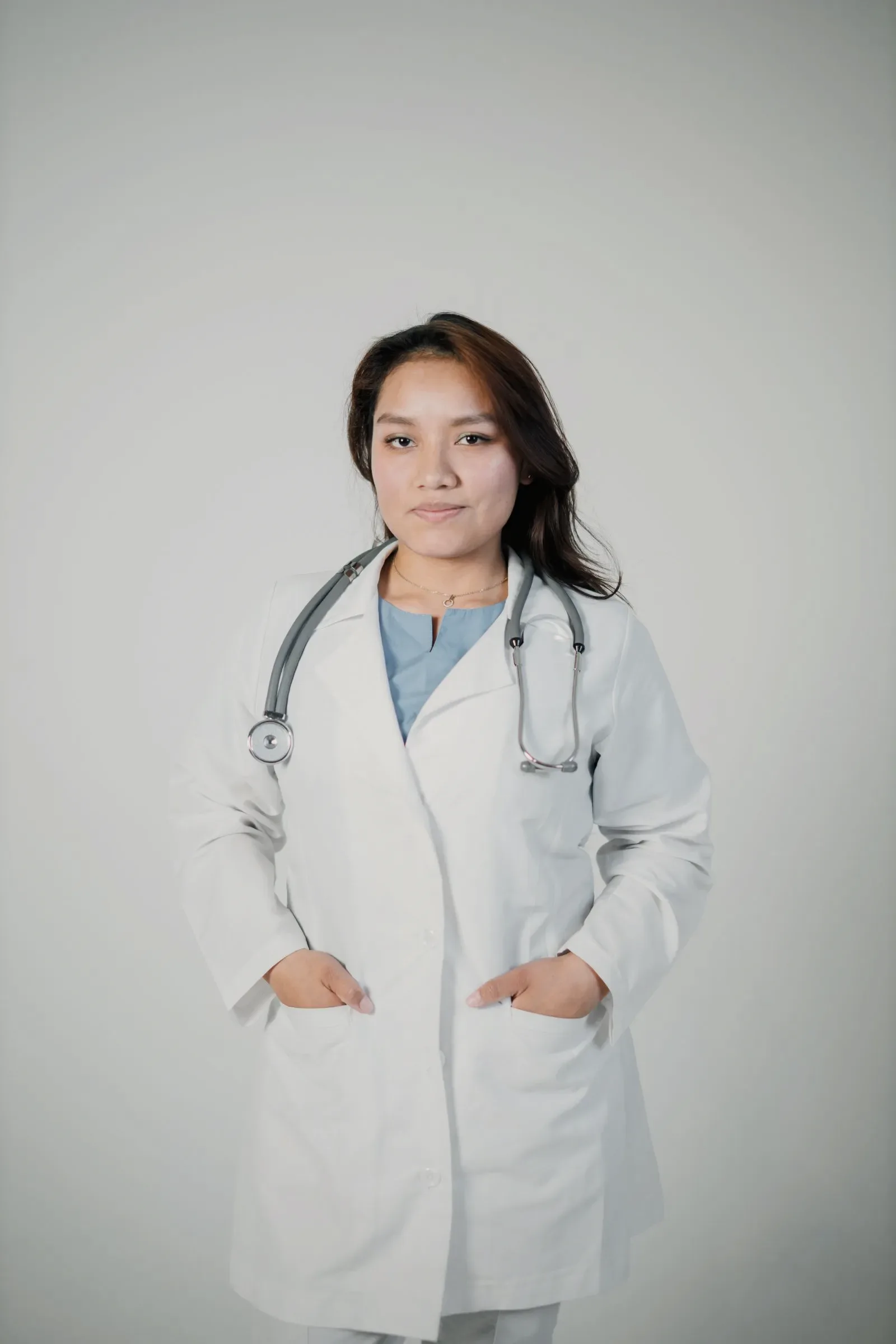 A surgeon photographed against a plain neutral background.