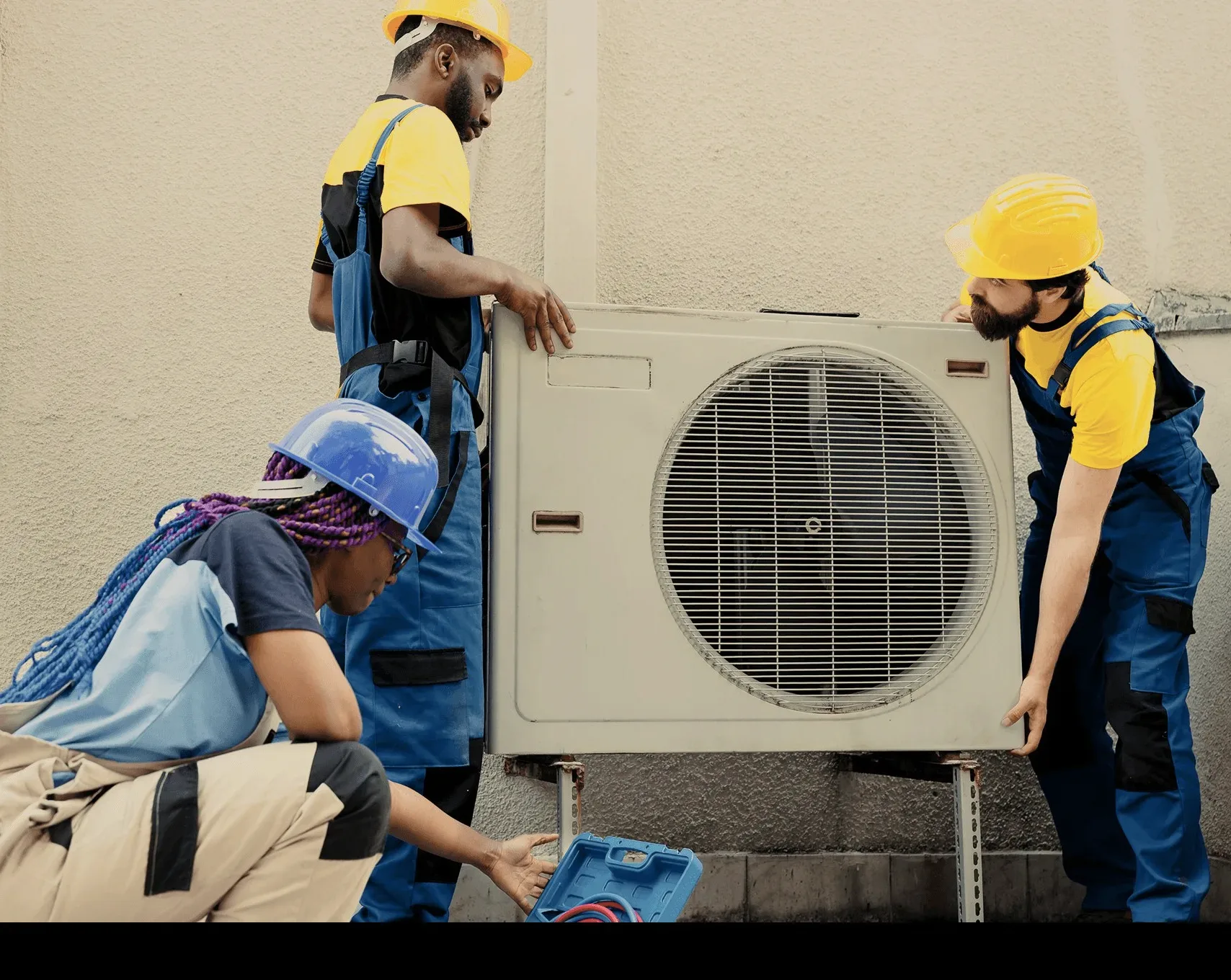 Two technicians setting an outdoor unit on its bracket.