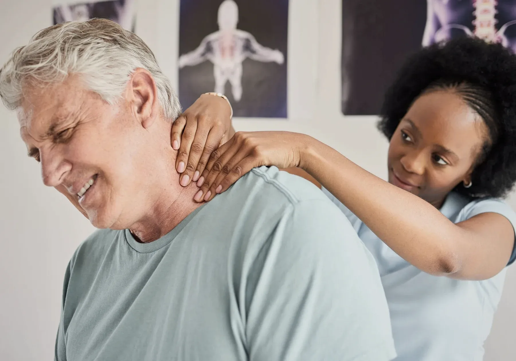 A chiropractor's hands on an older man's neck.