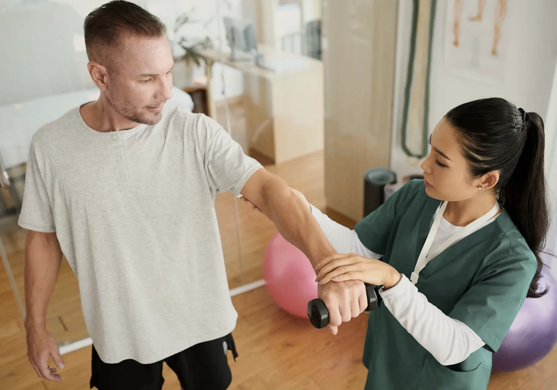 A rehabilitation specialist with a patient at a desk.