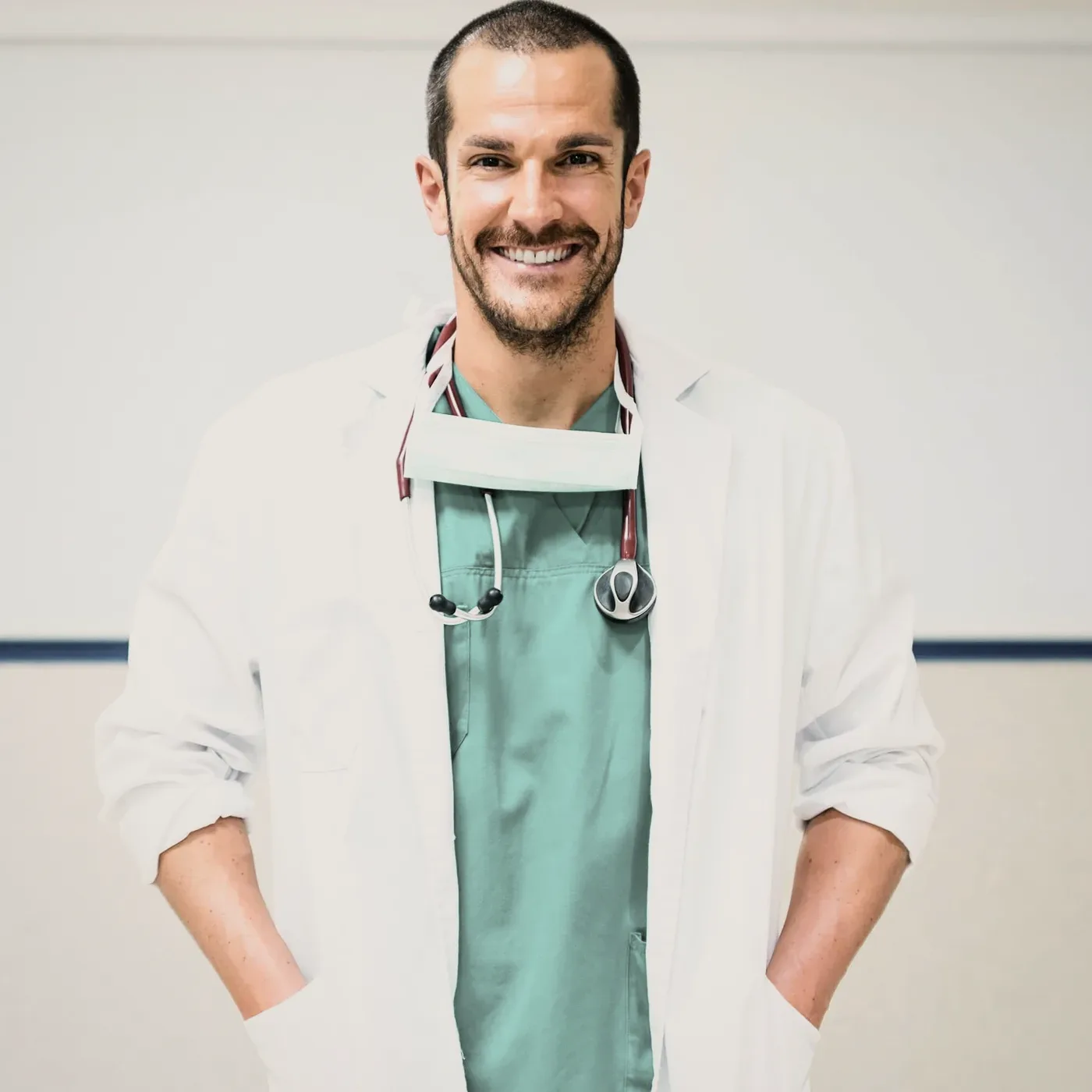 A smiling man in a white coat with a stethoscope.