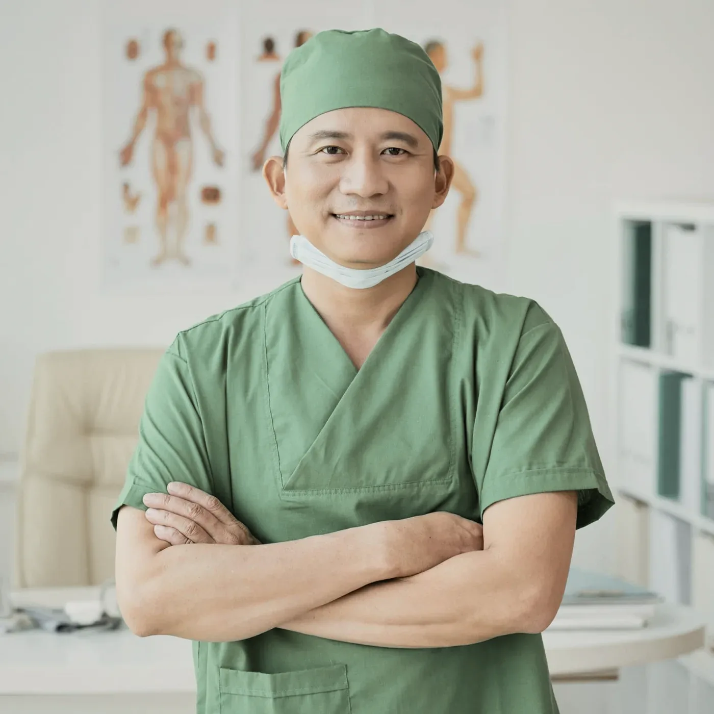 A man in a green surgical cap and mask.