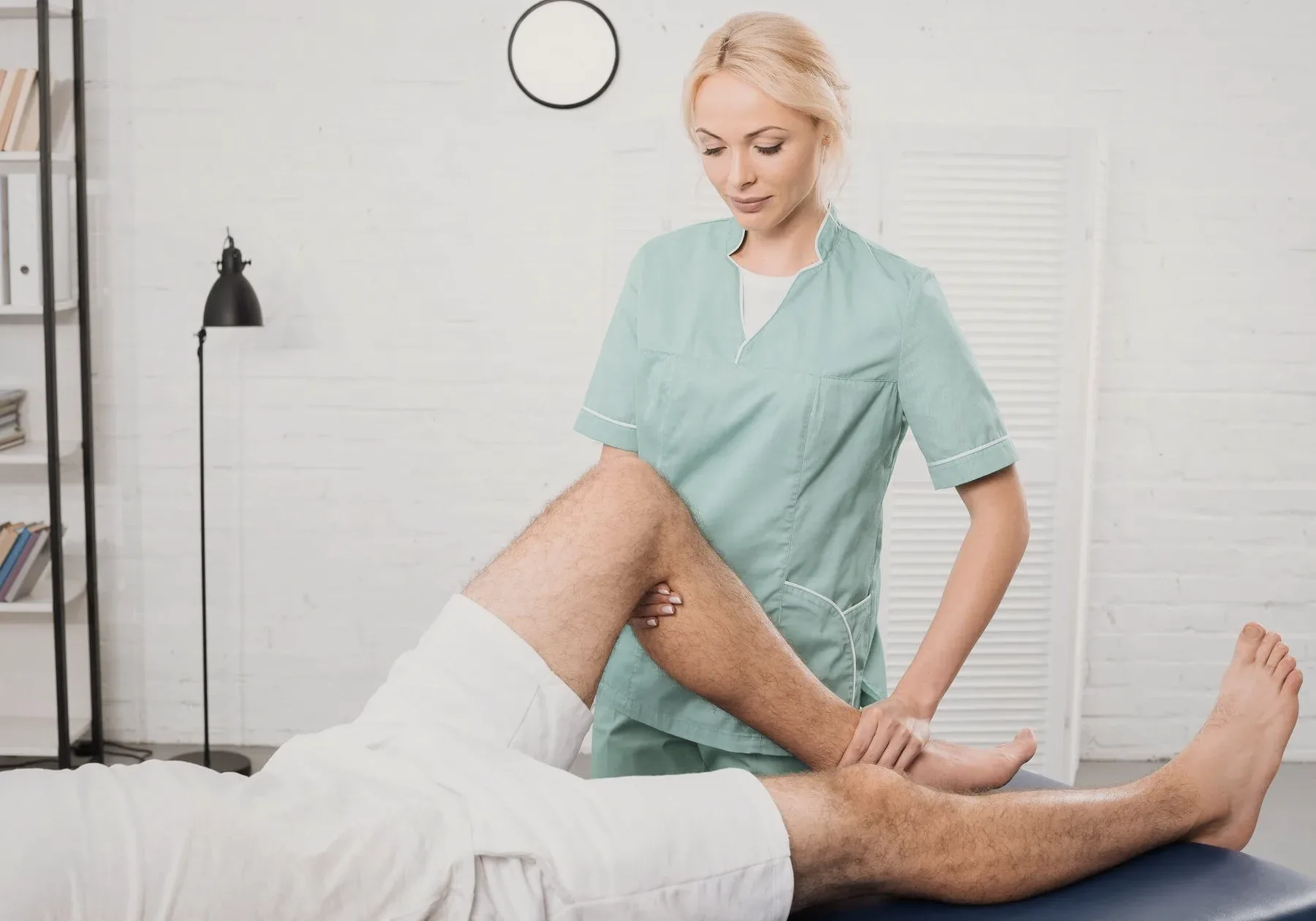 A chiropractor working on a patient's leg.
