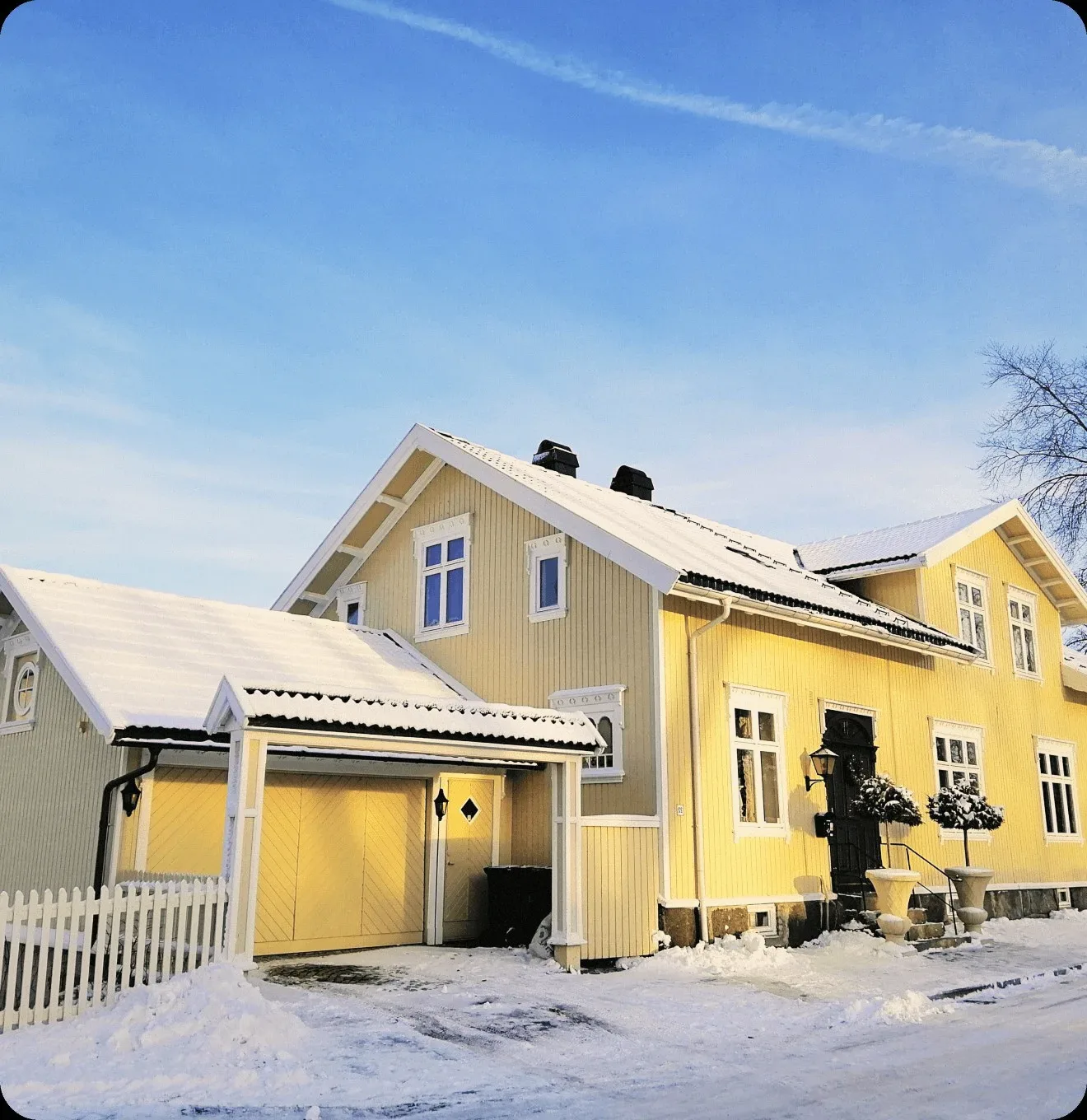 A yellow wooden house under snow.