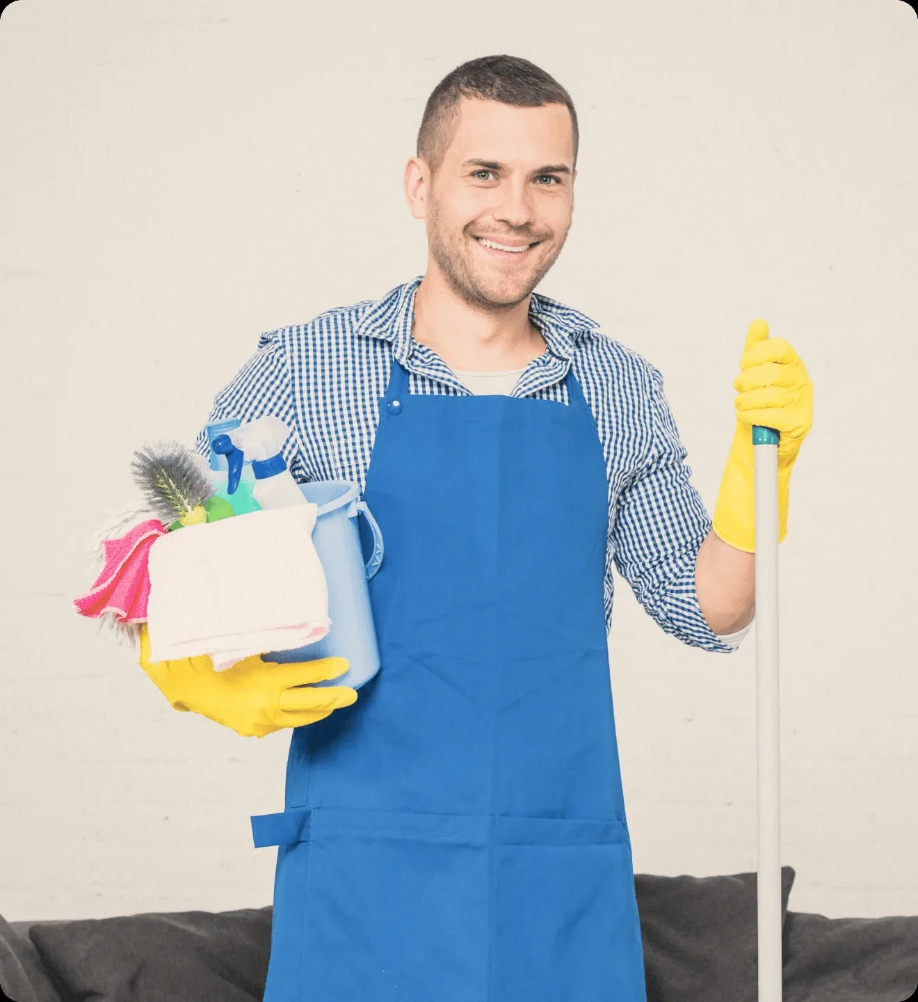 A cleaner in a blue apron with a mop and a caddy.