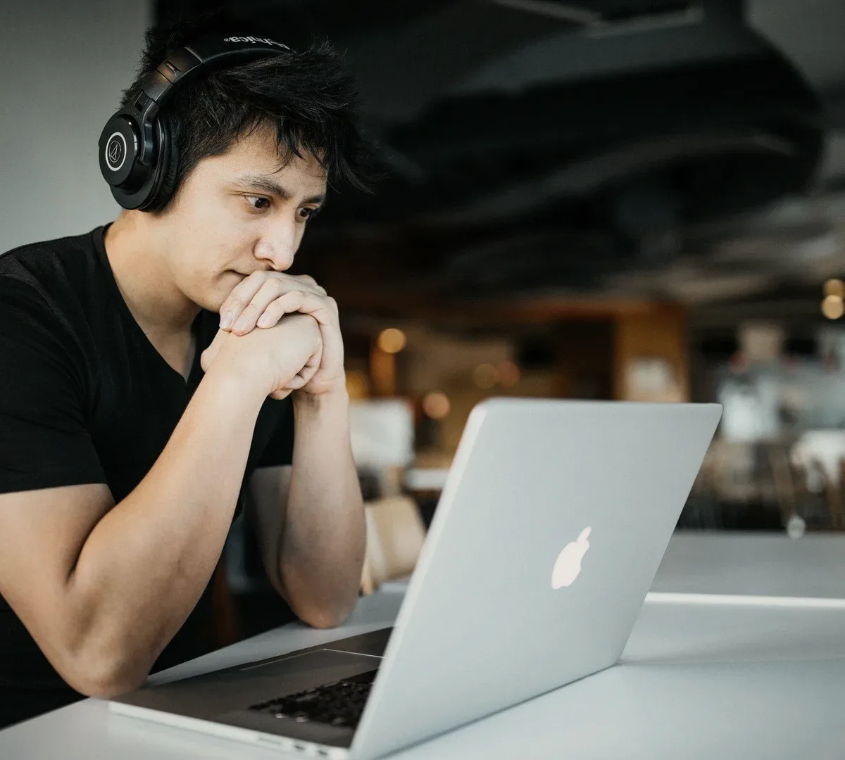 A man in headphones at a laptop.