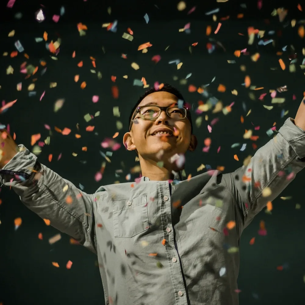 A person under falling confetti.