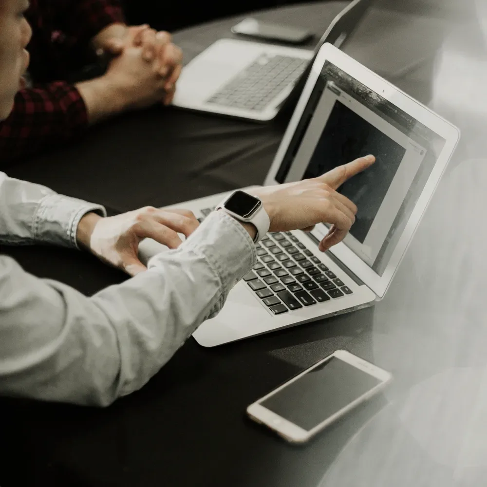 Hands on a laptop at a table.