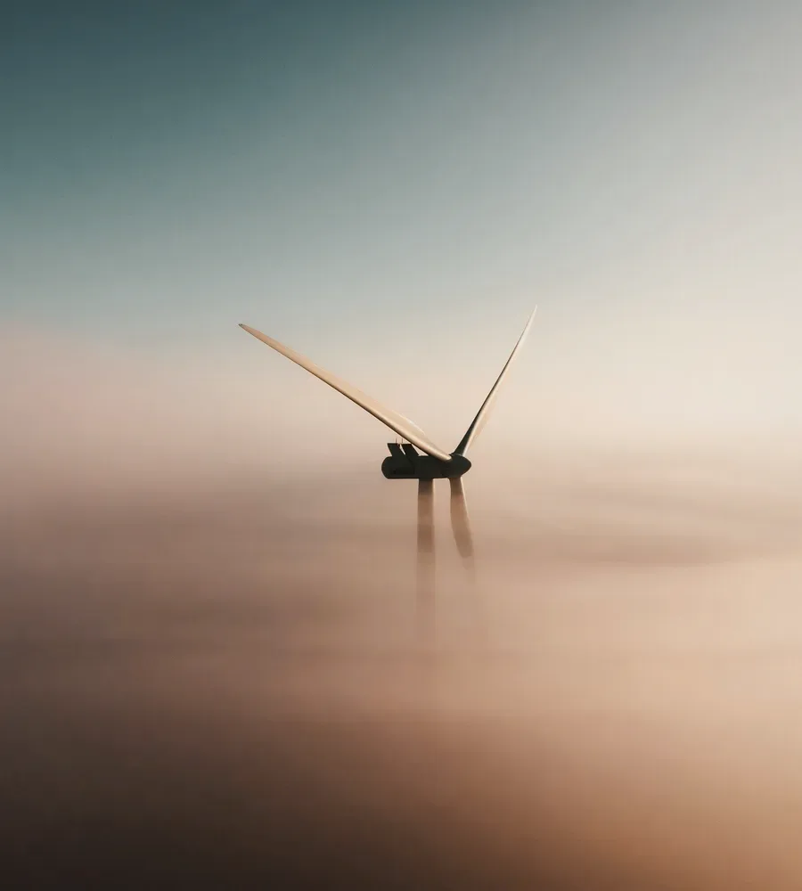 A wind turbine over the sea in haze.