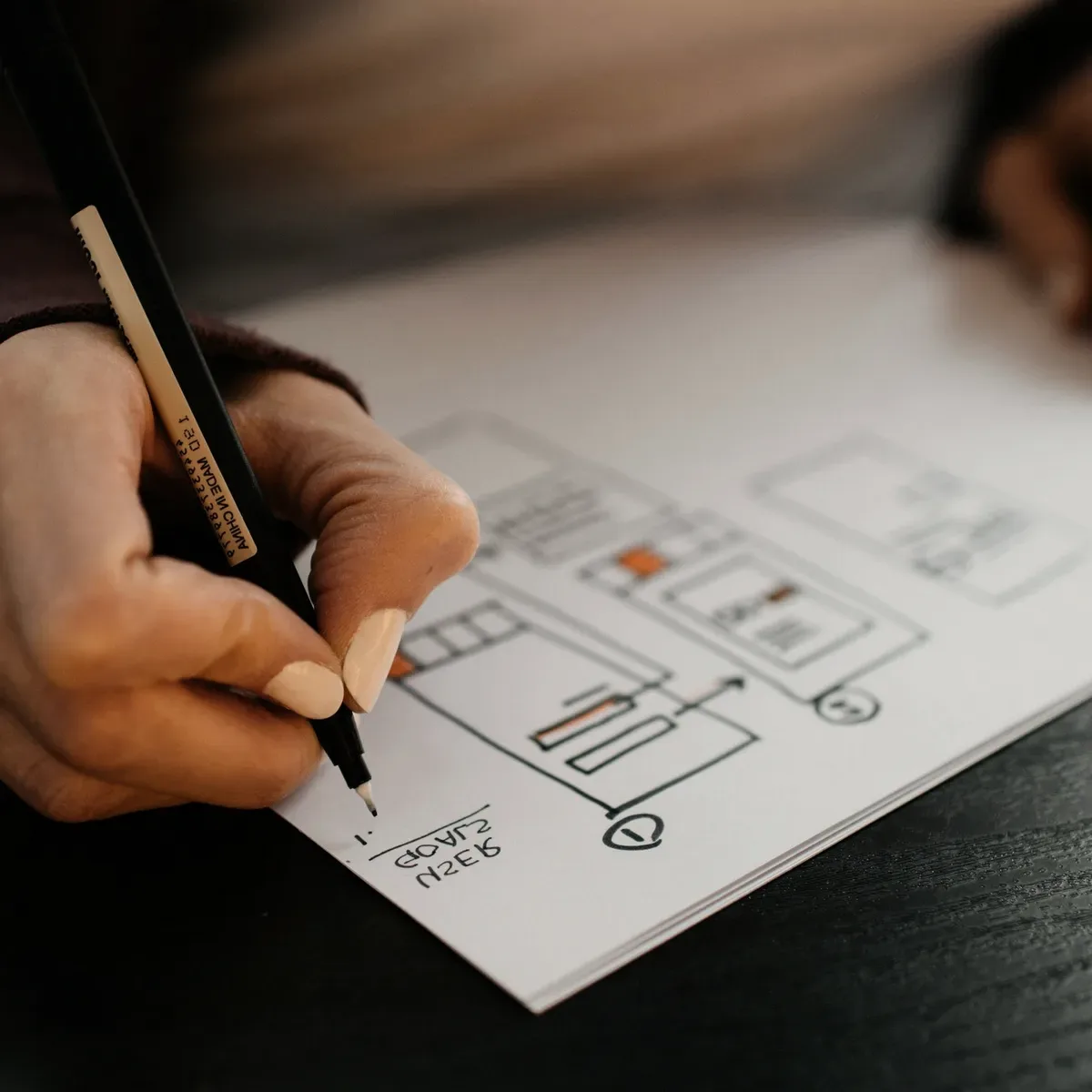 A hand sketching a plan on paper.