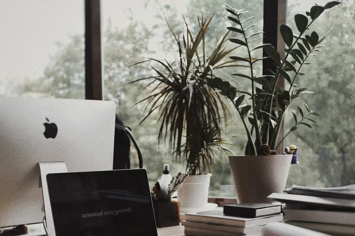 A laptop and papers on a desk.