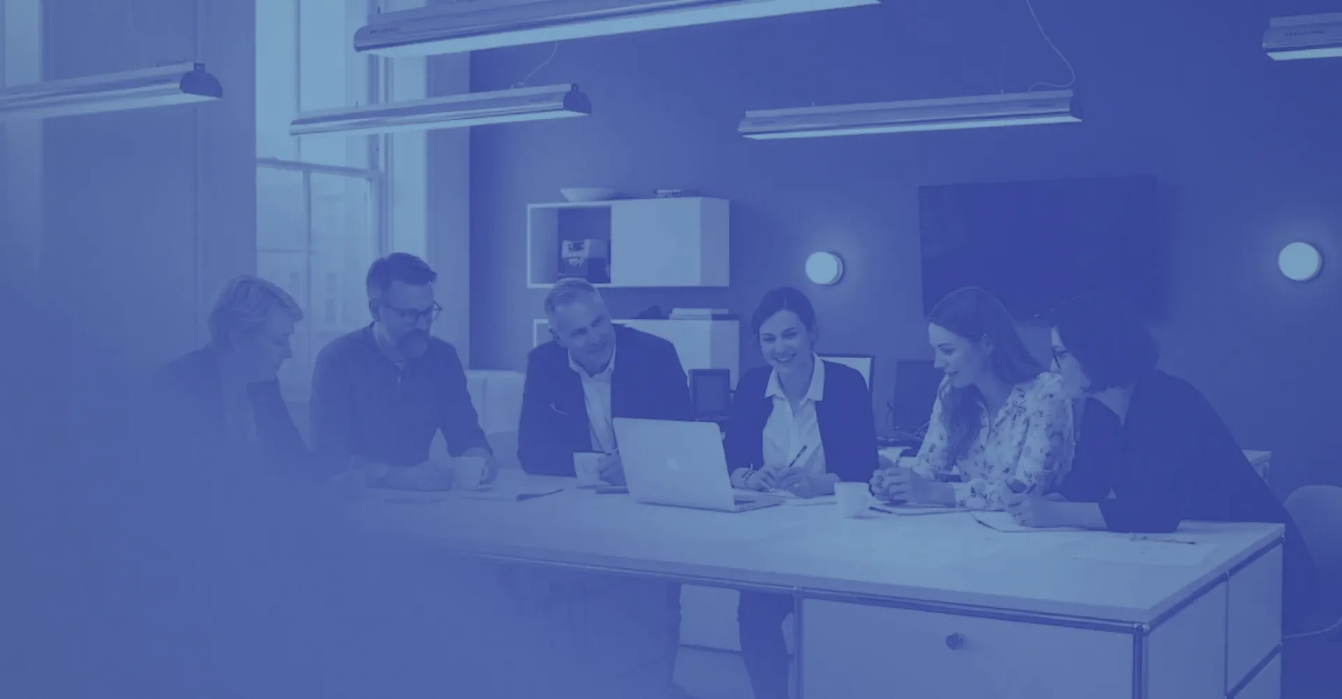 A team in a meeting room, in blue.