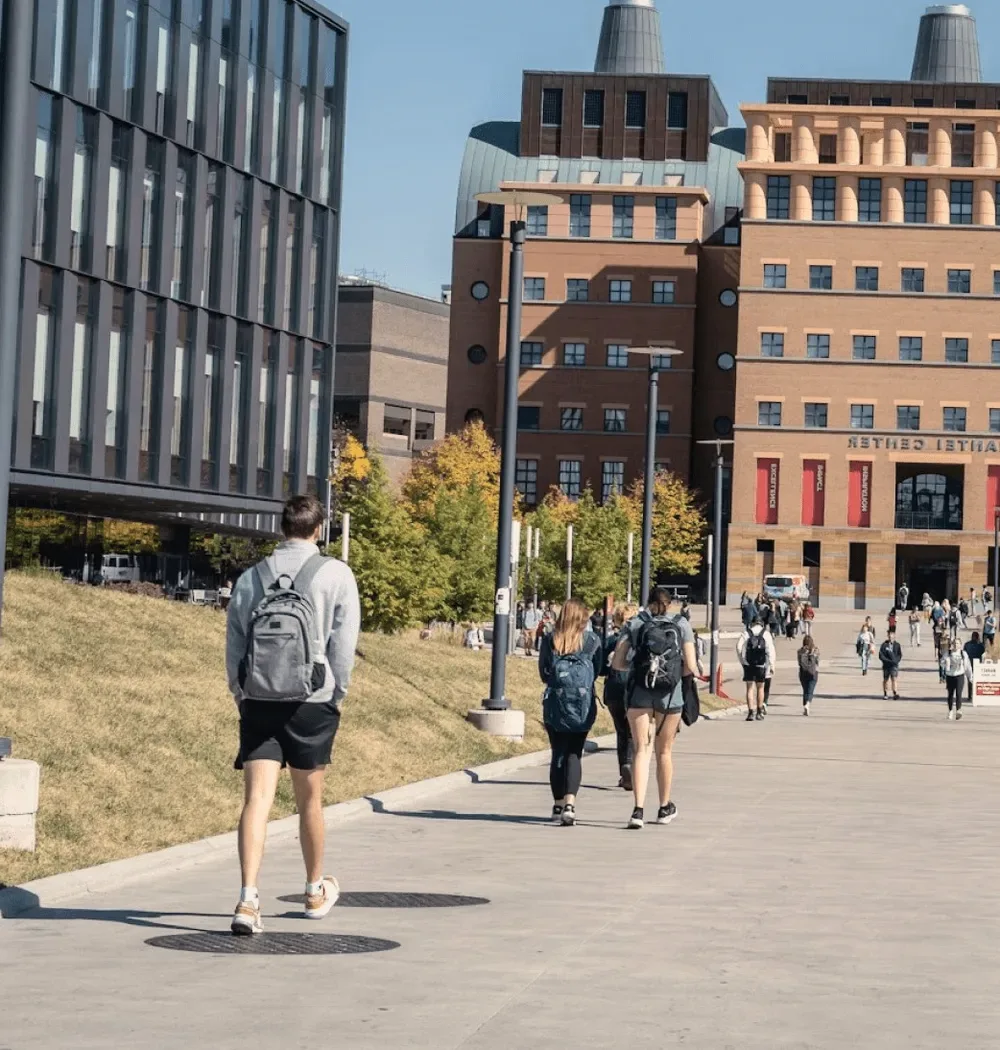 Students walking across campus in autumn.