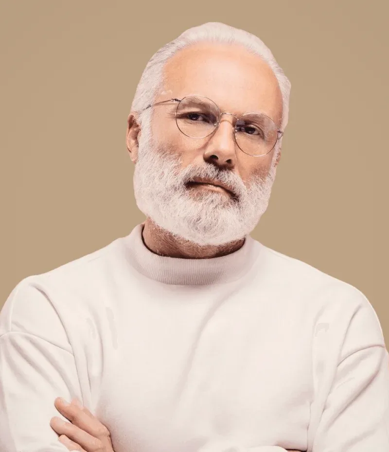 A man in a white jumper, arms crossed.