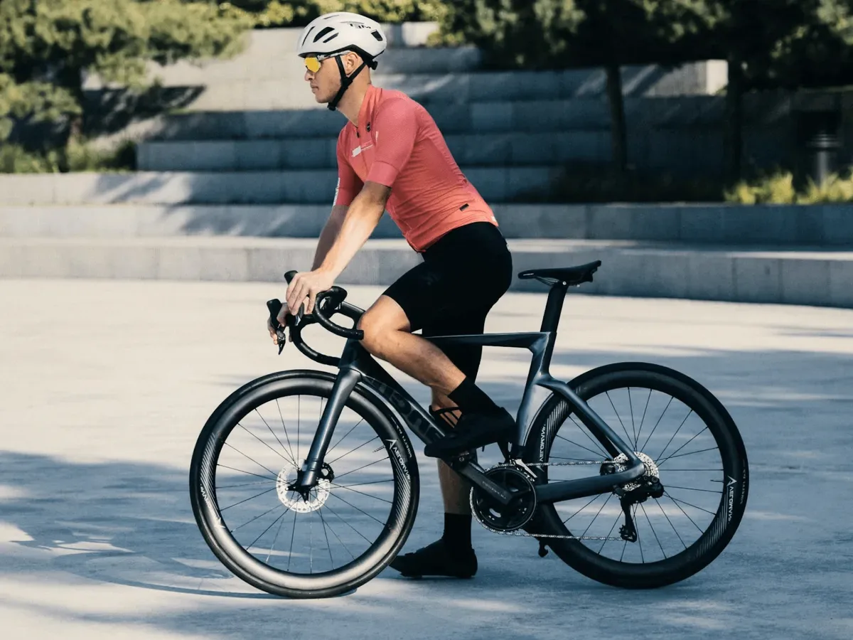 A cyclist in a red jersey on a city path.