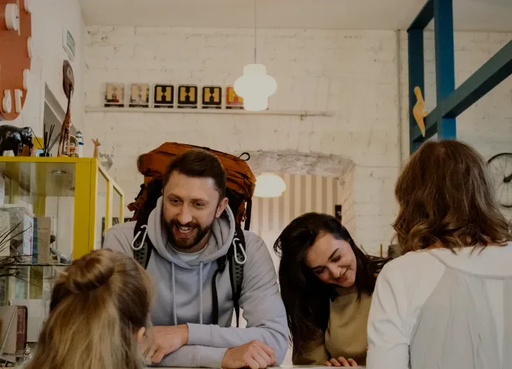 A backpacker laughing with friends at a table.