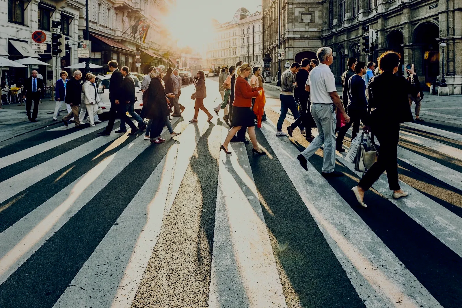 People crossing a sunny street in the city.