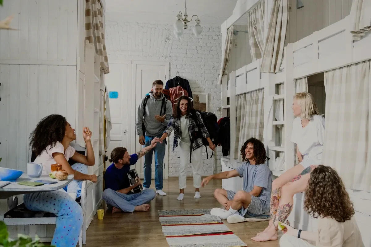 A group of friends in a dorm, laughing.