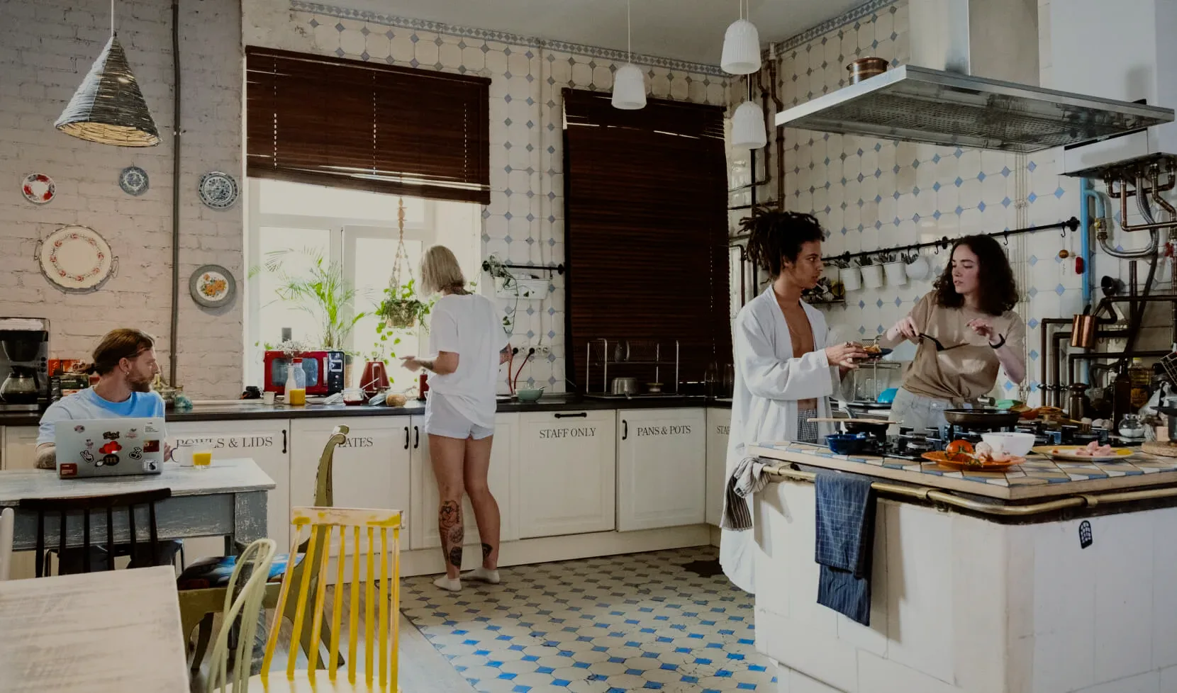 Guests cooking and talking in the shared kitchen.