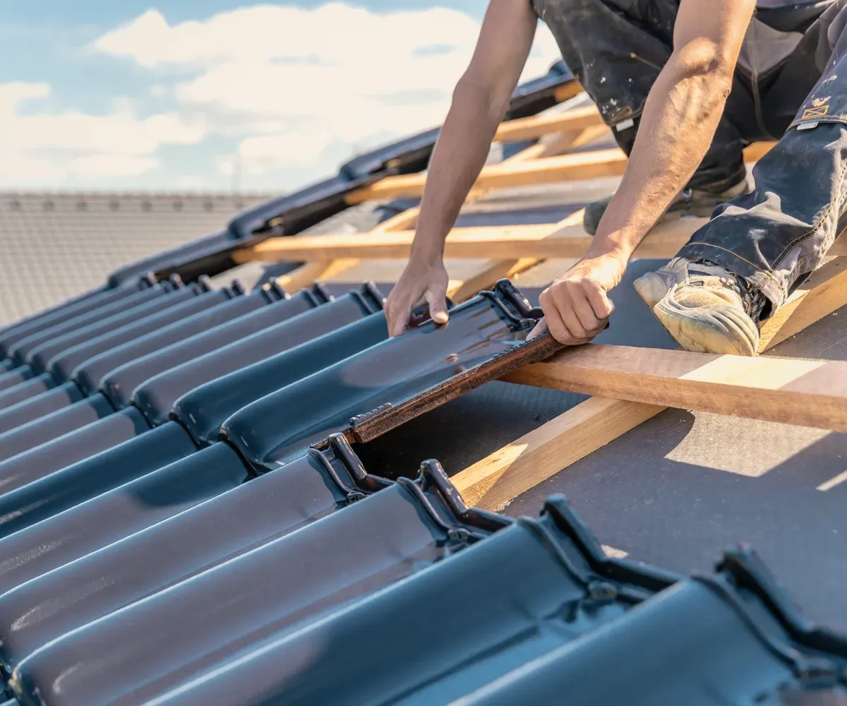 Hands laying blue tiles.