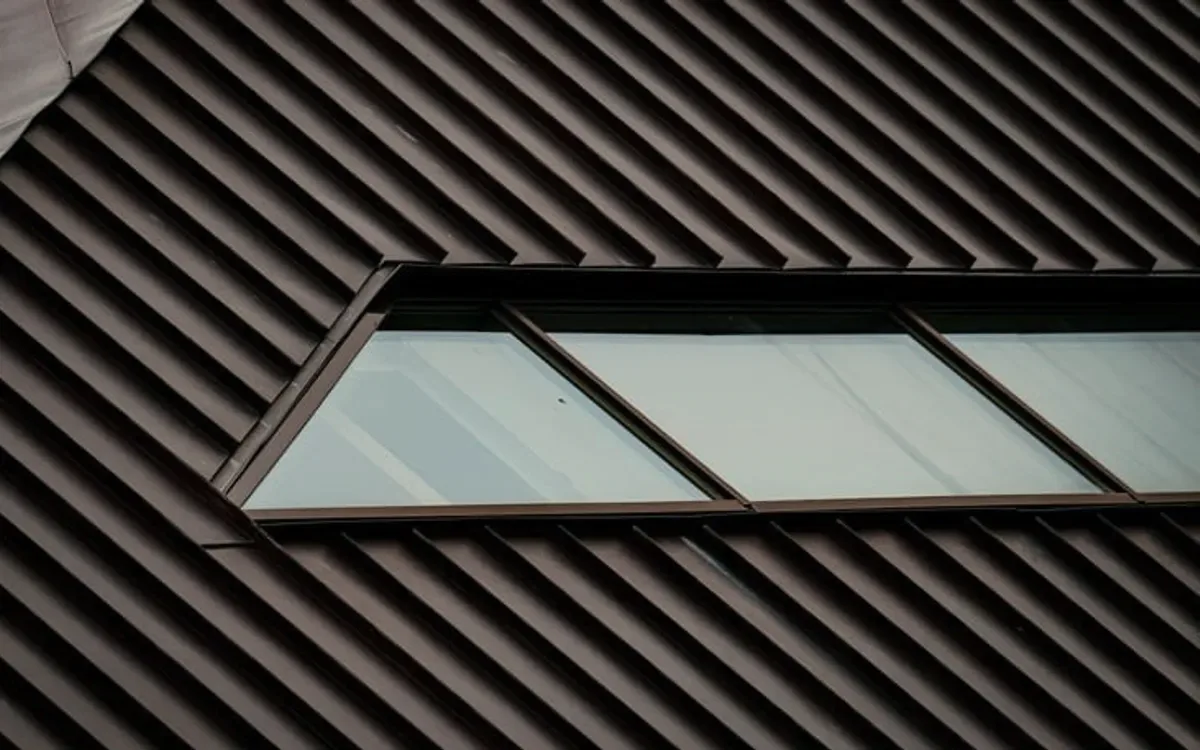 A dark metal roof with a window.