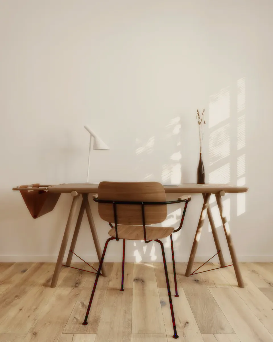 A wooden desk and chair with a white lamp and dried flowers.