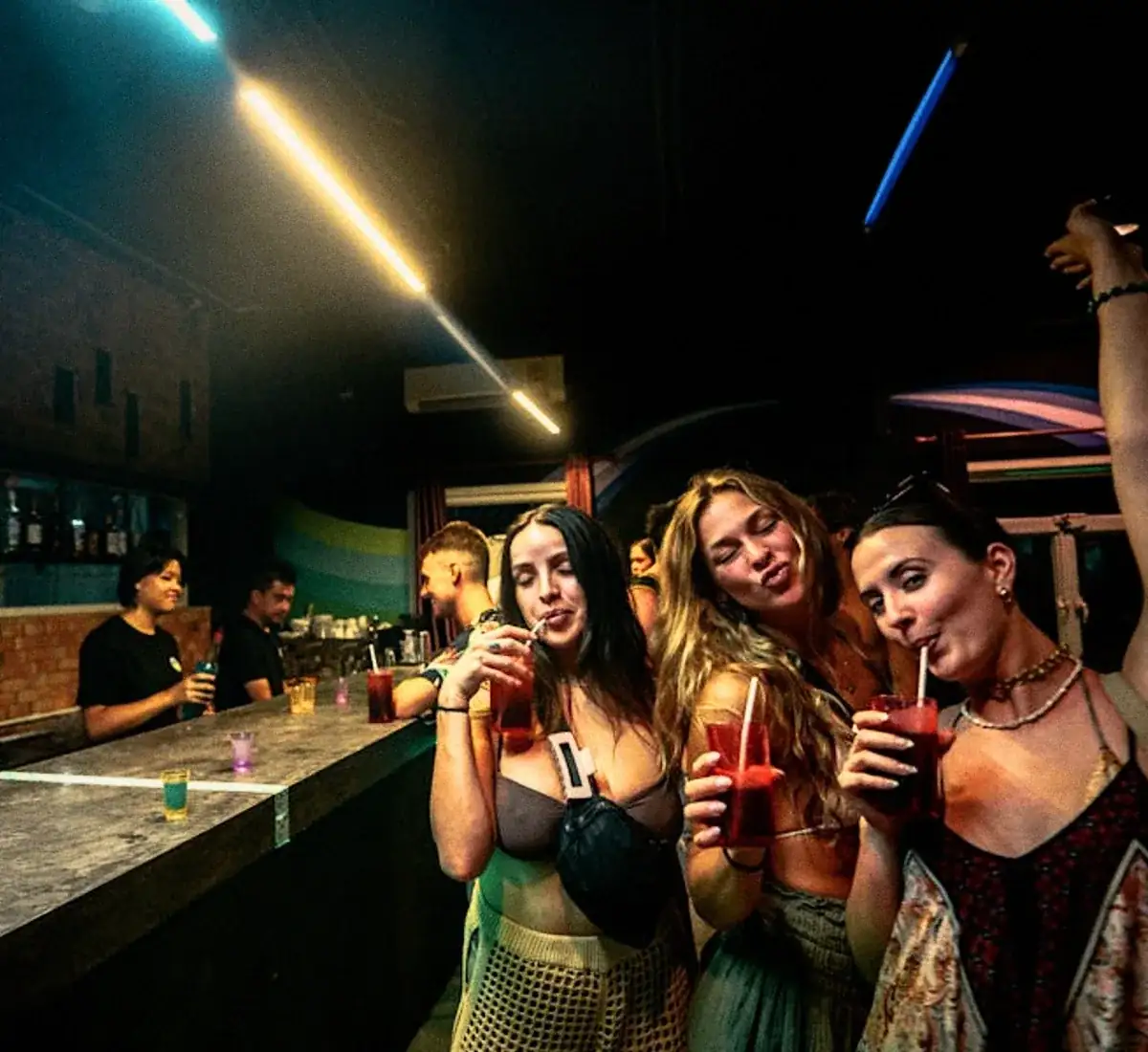 Guests raising their glasses at the bar at night.