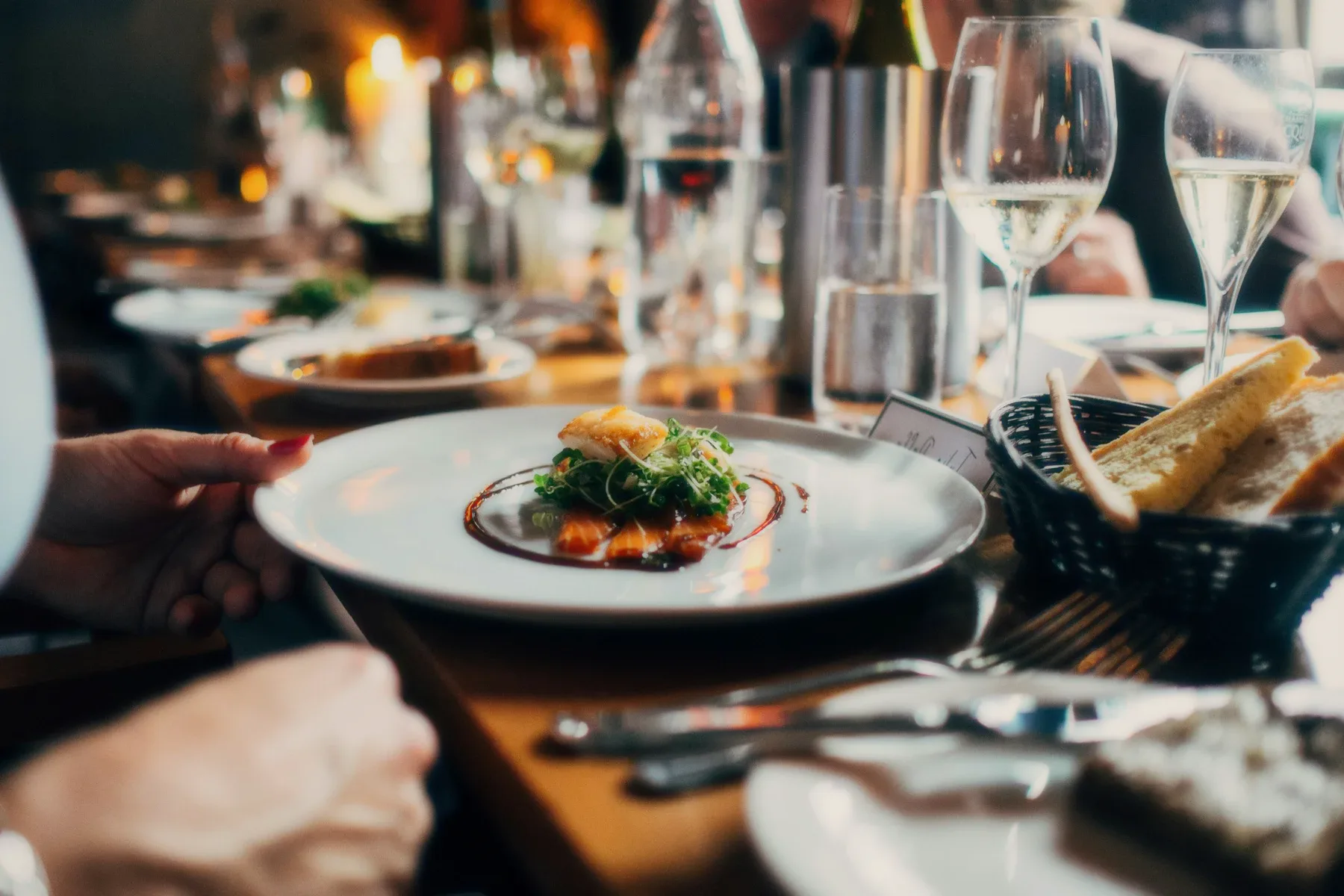 A dining table with glasses and a plate being served.