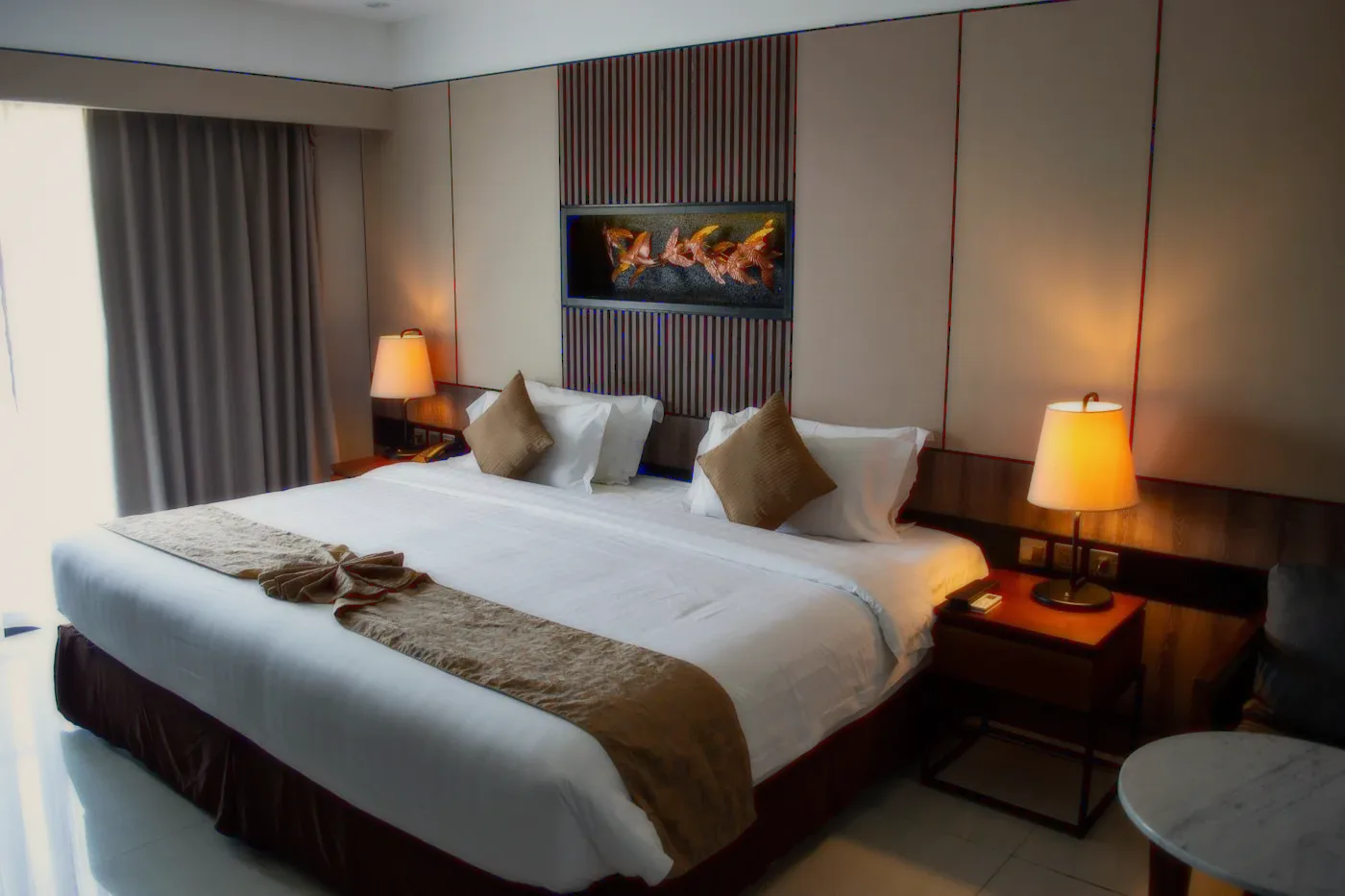 A room with a lamp and a bed with a runner.