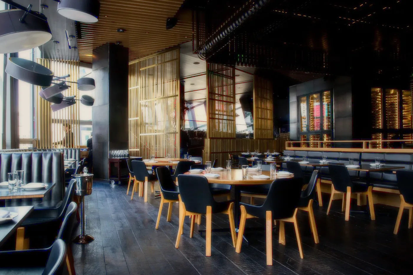 A restaurant with dark tables and lattice screens.