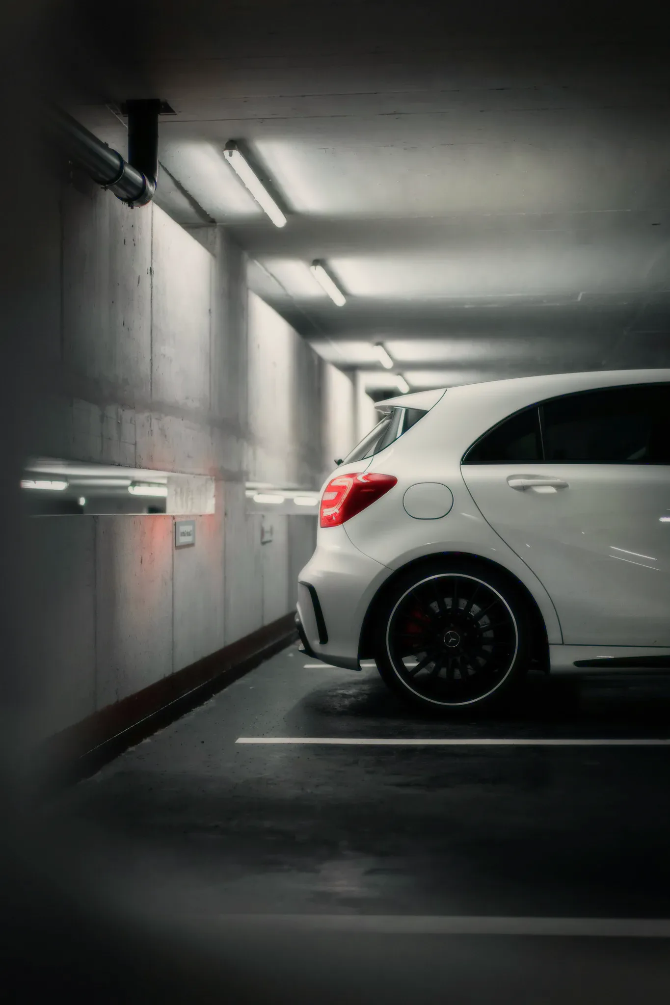 A white car in an underground garage.
