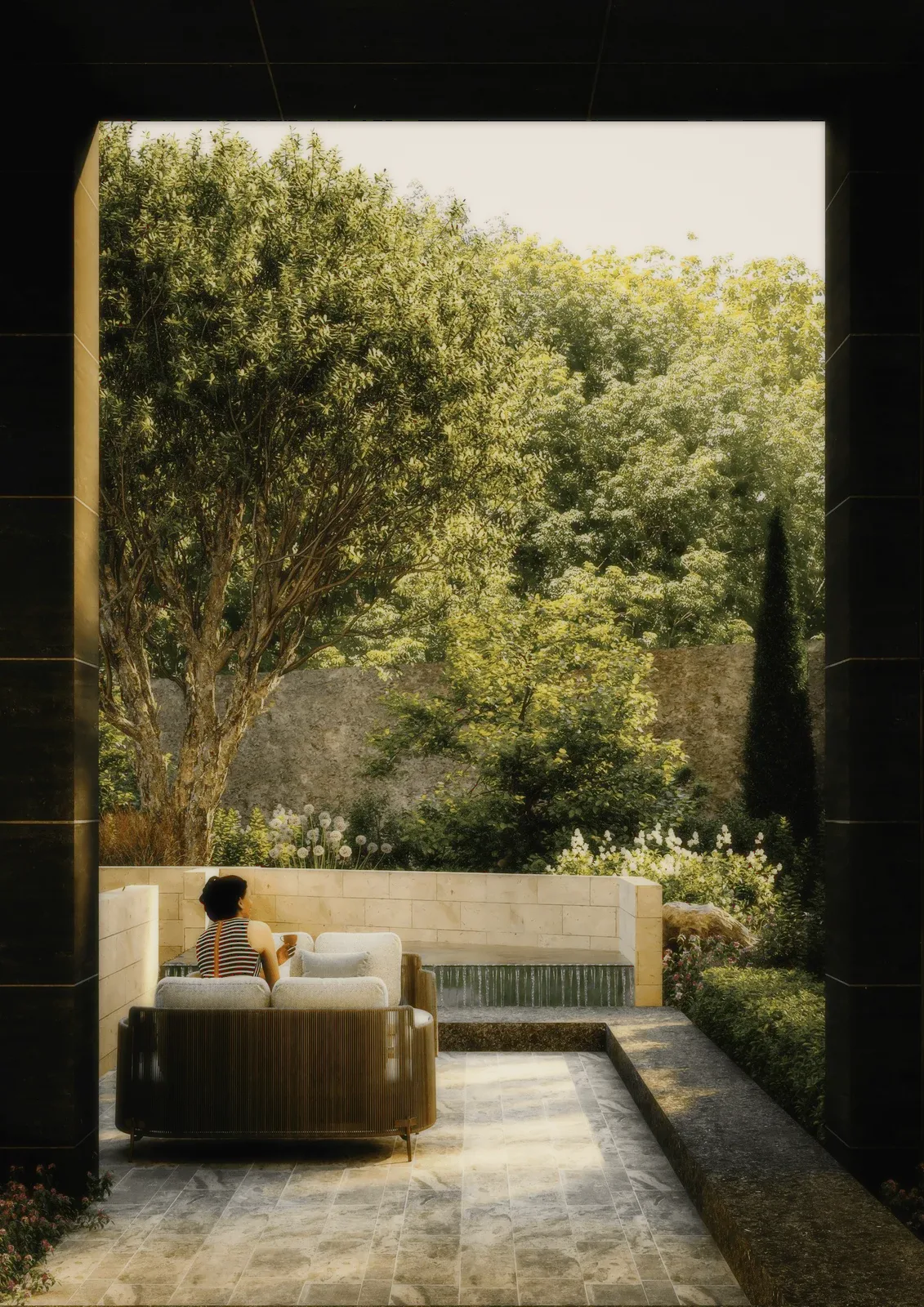A garden terrace with a sofa, walls and trees around it.