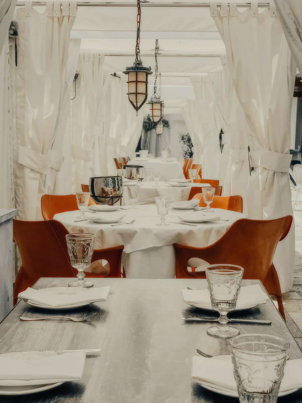 White tablecloths and leather chairs in a bright room.