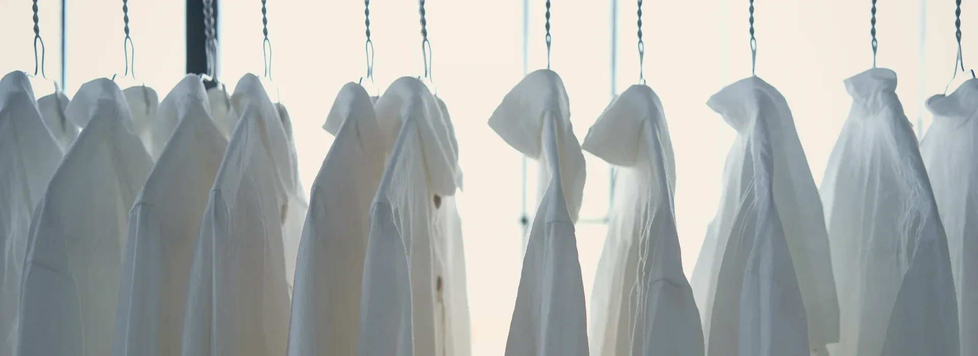 Shirts on hangers along a rail.