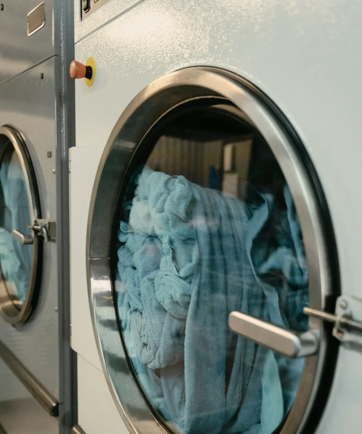 Blue towels in a front-loading dryer drum.