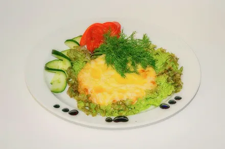 A salad with egg and tomatoes on a white plate.