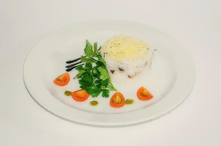 A plated starter with herbs and tomatoes.