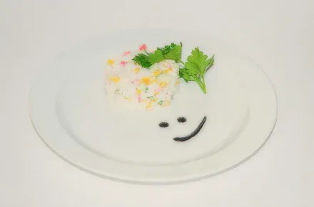 A round salad with herbs on a white plate.