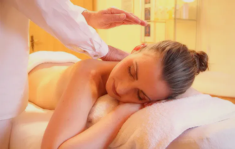 A woman resting during a back massage in a warm spa room.